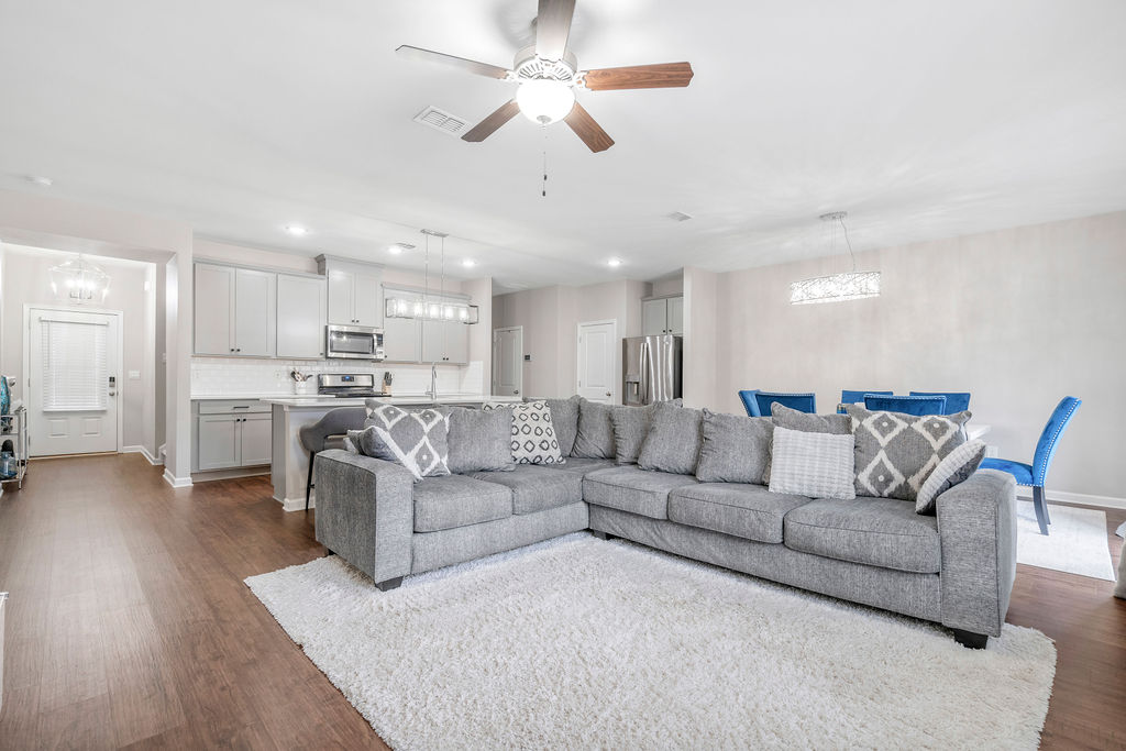 Spacious living room with sectional sofa and ceiling fan