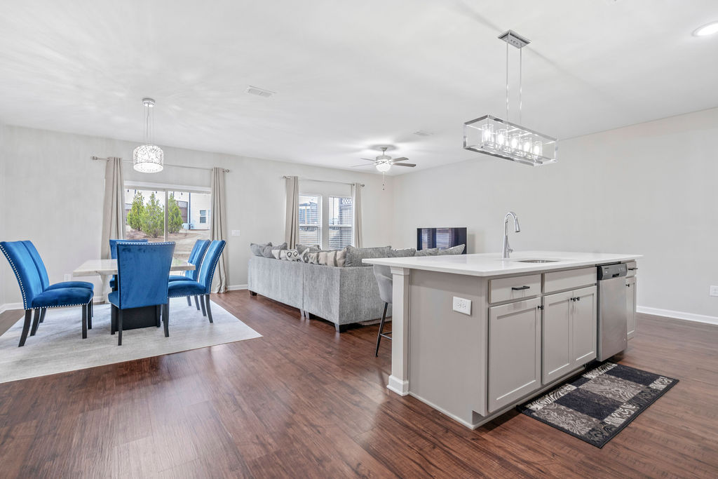 Open concept dining and living area with modern lighting